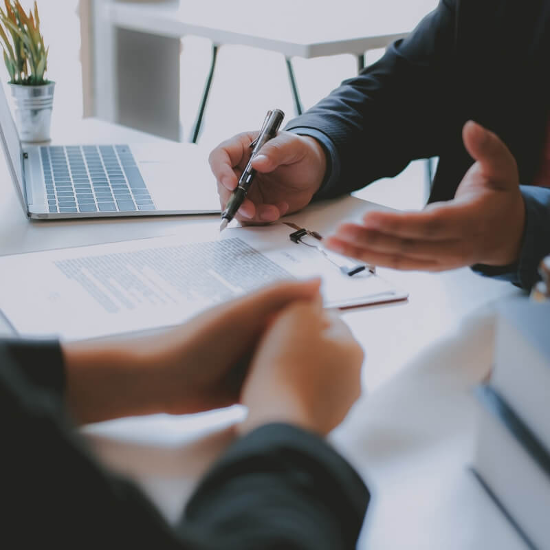 two people meeting across a desk where you can only see desk and hands